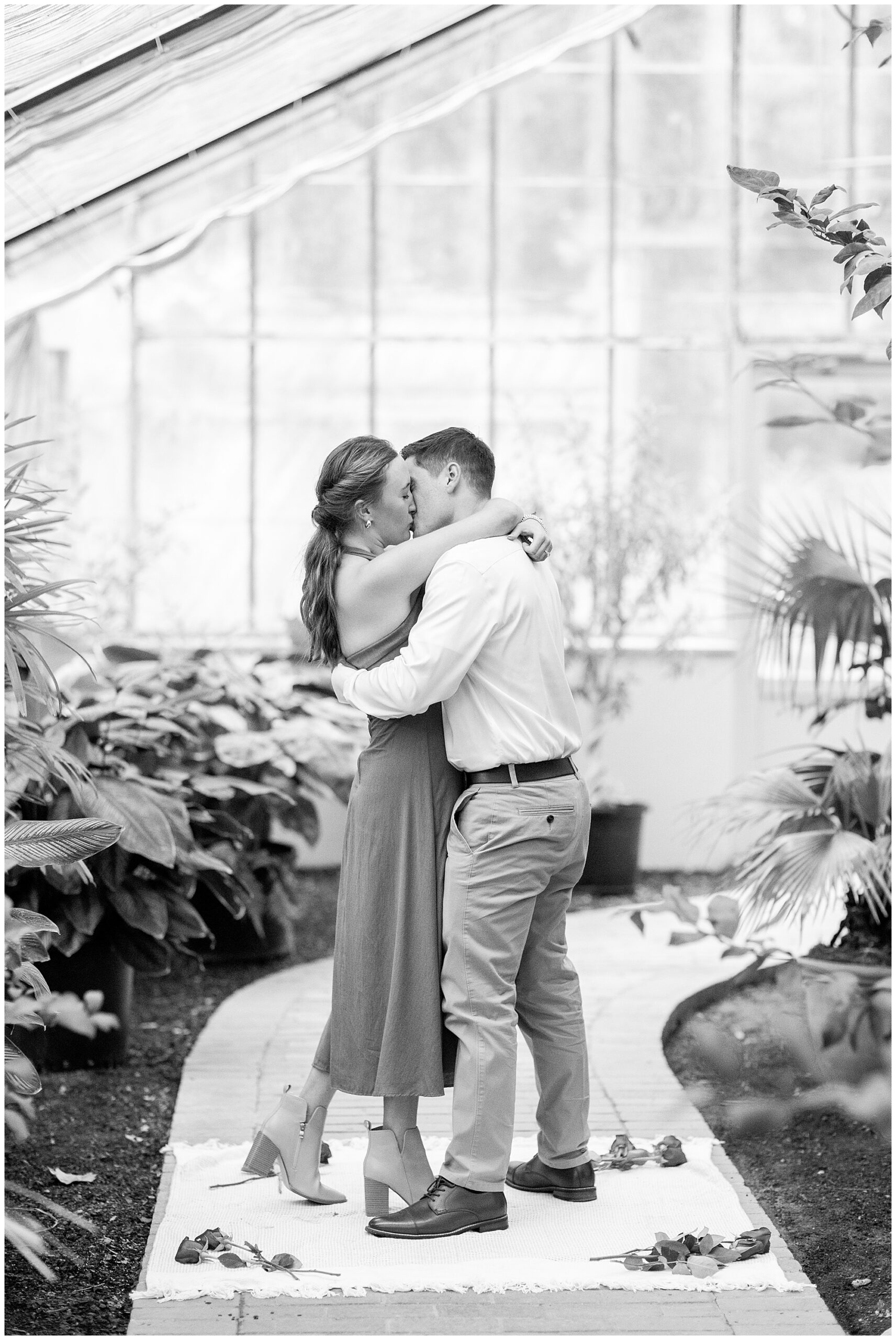 A black and white image of Catherine and Jake holding each other and kissing. 