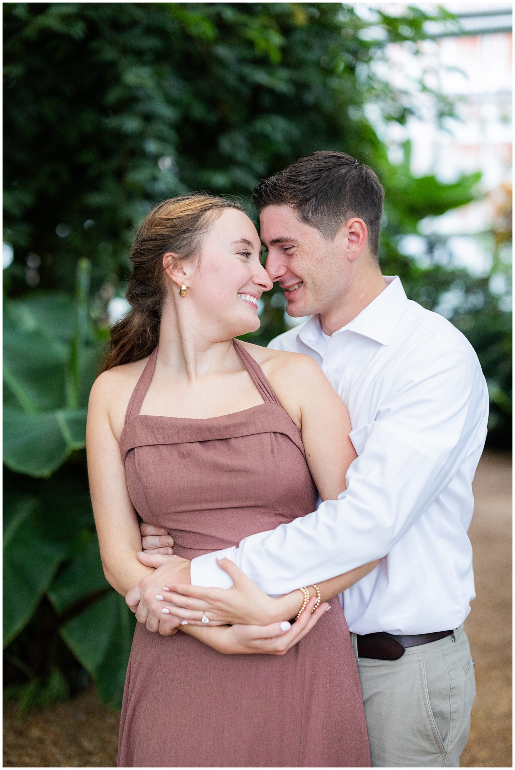 Jake holds Catherine from behind and they smile at each other. 